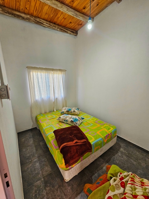 Habitación con cama doble y ventana luminosa