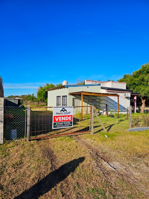 Casa en venta con cartel "Vende", imagen borrosa