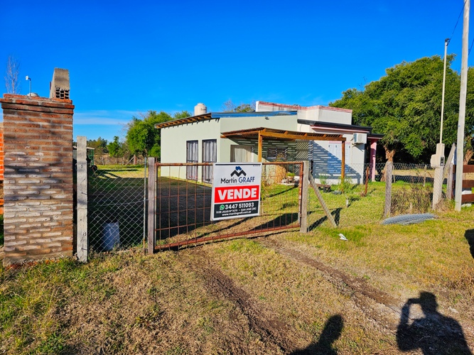 Imagen borrosa de casa en venta con cartel "Vende"