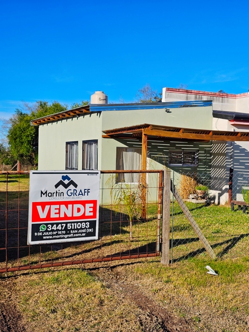 Casa en venta con cartel "Vende" desenfocado
